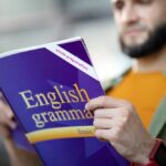 hombre leyendo un libro de ingles para ver Cómo Mejorar tu Vocabulario en Inglés